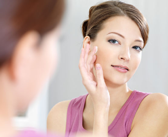 Woman applying sunscreen on her face