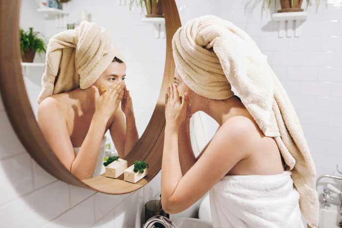 Women applying skin care cream on her face