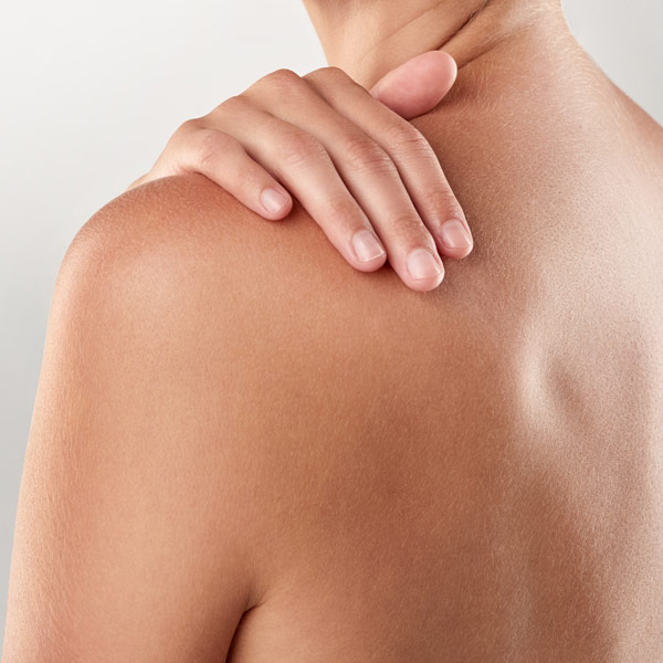 woman holding her shoulder
