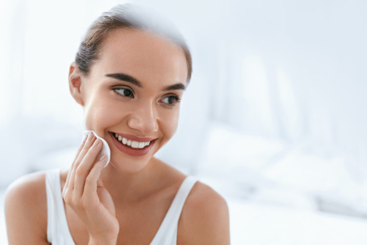 Beautiful Girl Cleaning Face Skin With White Cosmetic Pad.