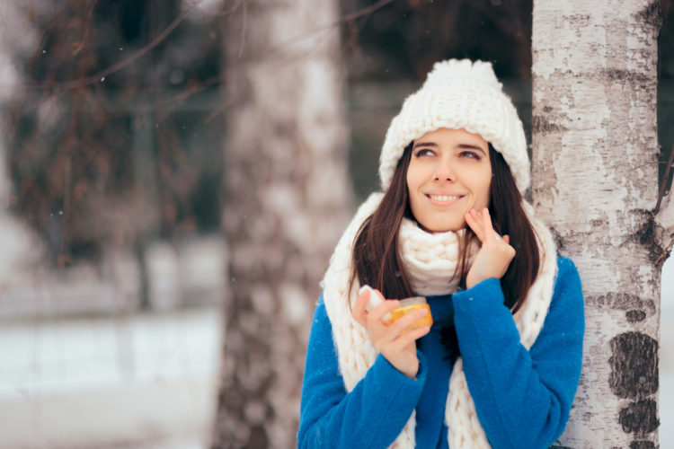 Cautious girl using anti aging sunscreen in wintertime