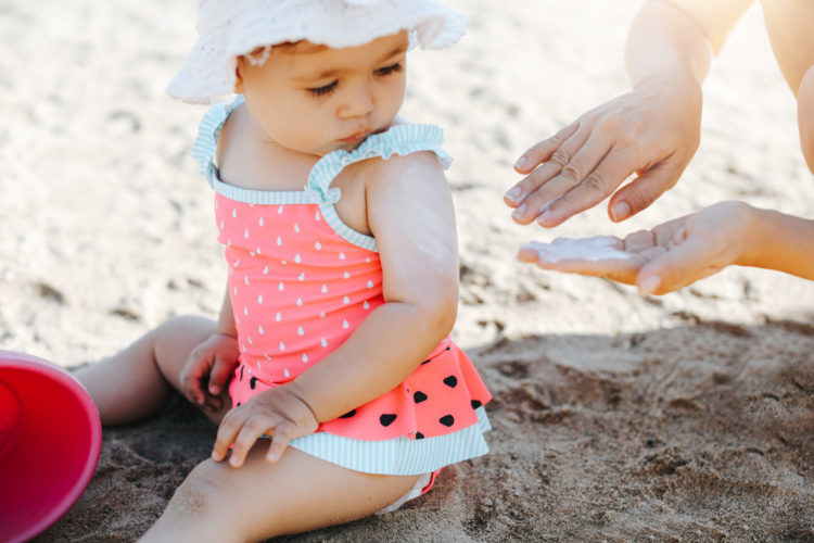 Happy laughing toddler girl having fun on sand