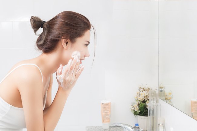 Women washing her face with cream