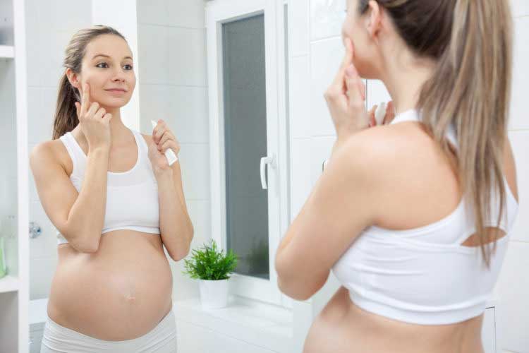 Pregnant women looking into mirror