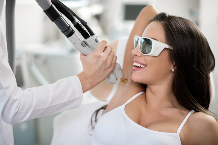 Young woman is having her armpit hair removed with medical laser procedure.
