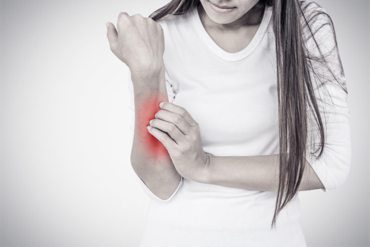 Woman scratching her hand on white background.