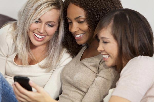 Three female friends watching at mobile