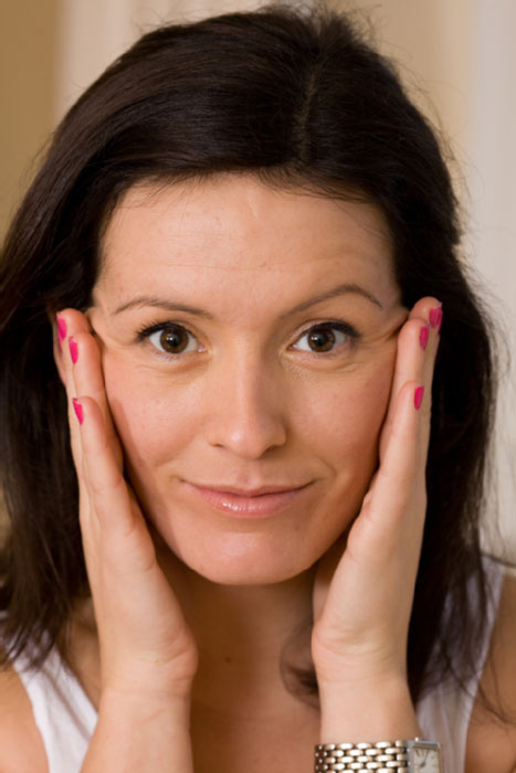 Young woman holding her face