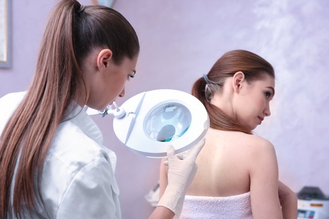 Female doctor checking Grover’s disease of a female patient