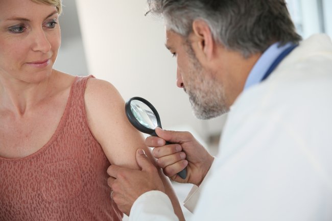 Senior doctor checking female patient