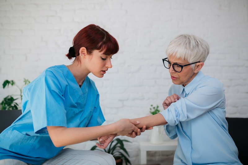 A senior woman having her arm looked at by a professional by Swinyer Woseth Dermatology
