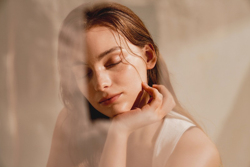 A woman with her eyes closed, showing a bright and clear complexion by Swinyer Woseth Dermatology
