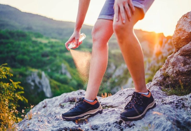 A man is applying a spray on his leg to prevent bug bites in Salt Lake City & South Jordan, UT