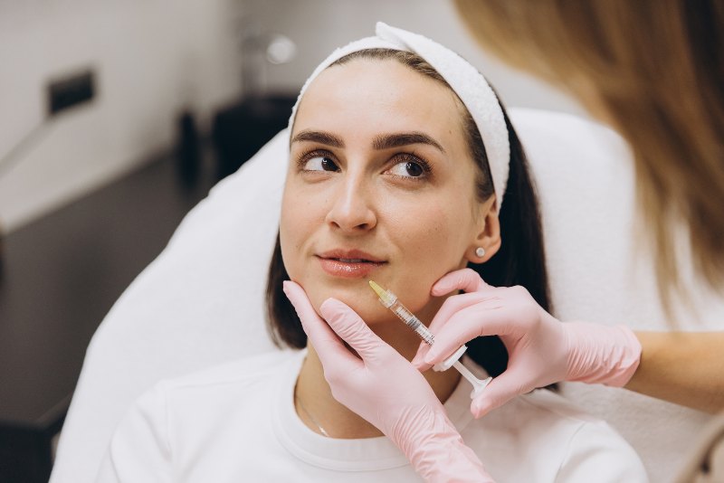 A woman receiving fillers near her lip from a professional by Swinyer Woseth Dermatology