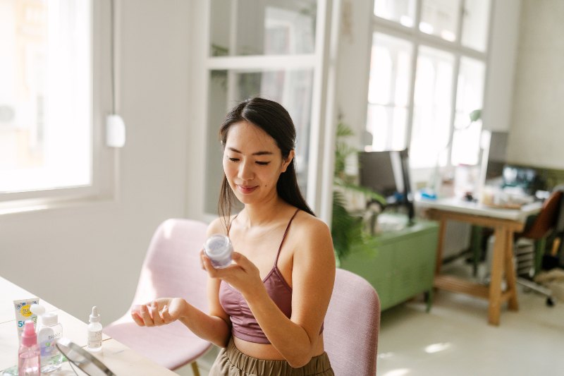 A woman looking at her skin care routine by Swinyer Woseth Dermatology