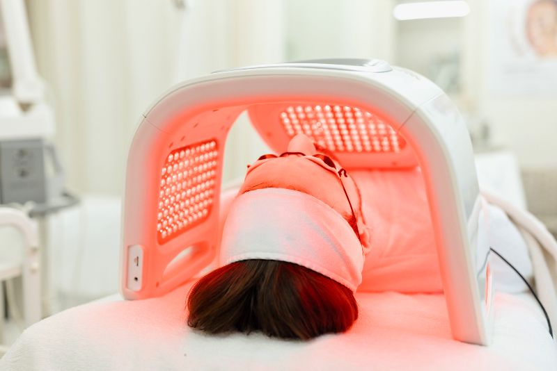 A woman getting red light therapy on her face by Swinyer Woseth Dermatology
