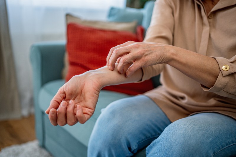 A woman scratching eczema on her forearm by Swinyer Woseth Dermatoloy